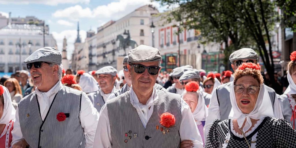 Grupo de chulapos vestidos de blanco paseando por Madrid en San Isidro 2026