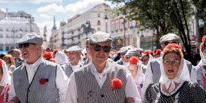 Grupo de chulapos vestidos de blanco paseando por Madrid en San Isidro 2026