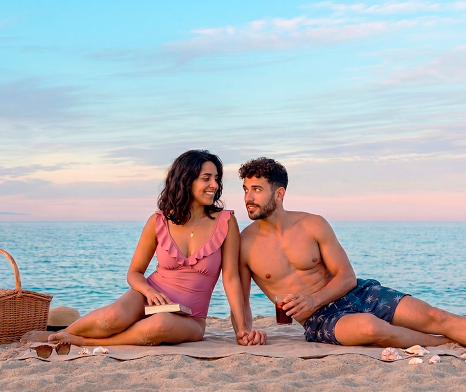 Pareja disfrutando en la playa al atardecer antes del sorteo extraordinario de vacaciones.
