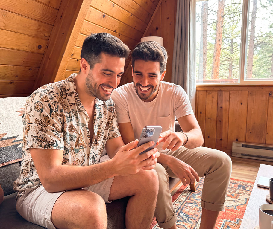Dos amigos consultan en el móvil el Sorteo Extraordinario de Agosto 2026 durante sus vacaciones