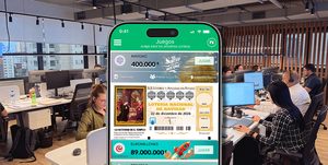 Móvil con la app de TuLotero en una oficina para organizar la lotería de empresa 2026.
